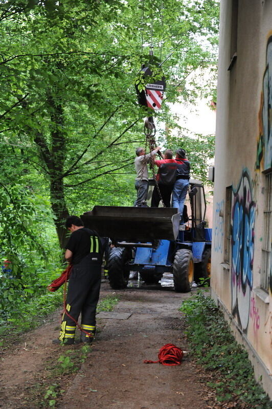 Kran zieht Baumaschine aus dem Neckar