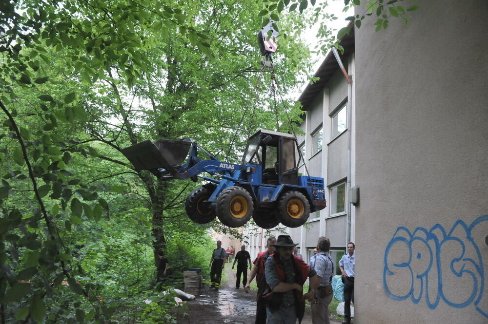 Kran zieht Baumaschine aus dem Neckar