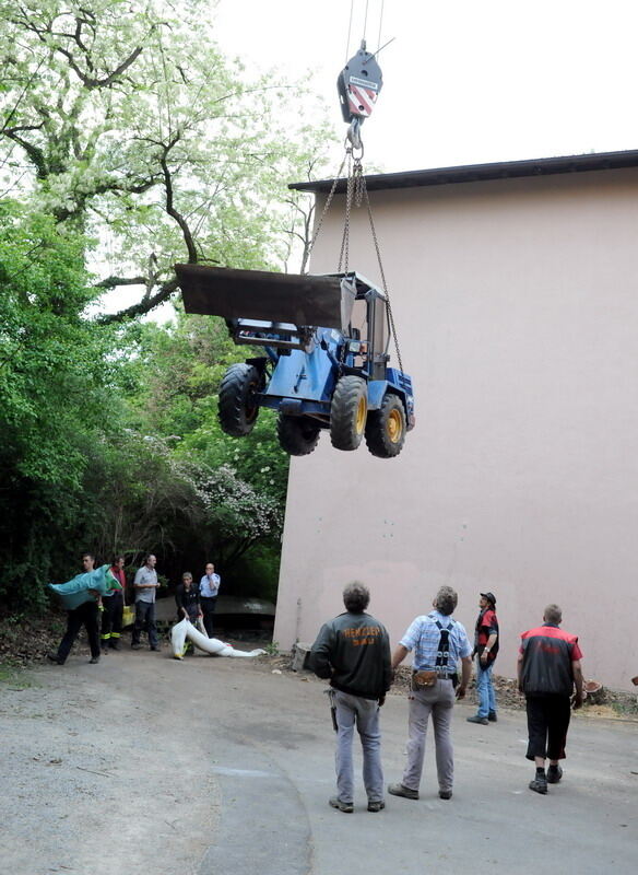 Kran zieht Baumaschine aus dem Neckar