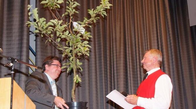 Hülbens Bürgermeister Siegmund Ganser überreicht Heinz Christner (rechts) einen Apfelbaum. Zuvor wurde Christner mit der Ehrenme