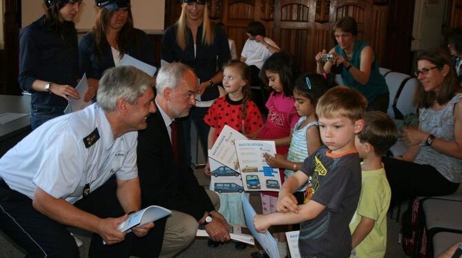 Polizeidirektor Franz Lutz (vorne links) und Landrat Thomas Reumann drückten den Kindergartenkindern das Malbuch in die Hand. FO