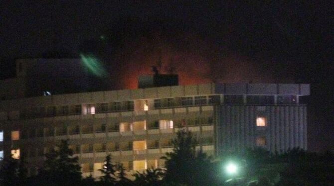 Der Schein eines Feuers erleuchtet den Himmel über dem umkämpften Hotel.