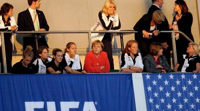 Bundeskanzlerin Angela Merkel (in rot) schaut zusammen mit dem DFB-Team das Spiel Schweden - USA.