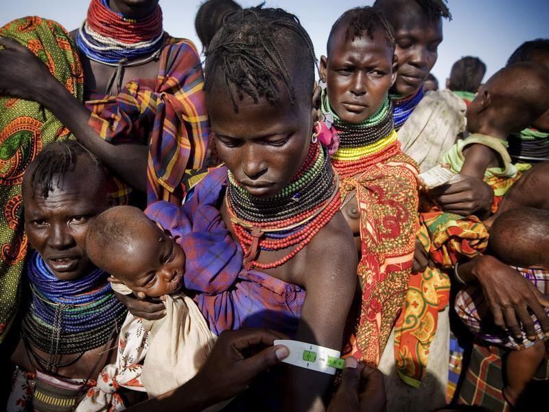 Ein UNICEF-Mitarbeiter misst den abgemagerten Arm einer stillenden Mutter in Kenia, um herauszufinden, ob sie unternährt ist.