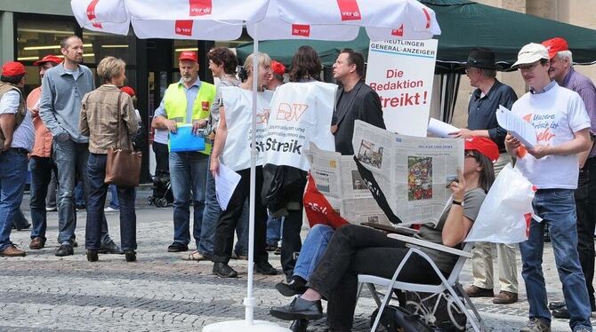 Streikende Redakteure des Reutlinger General-Anzeigers informierten mit einem Stand an der Marienkirche.  GEA-FOTO: MEYER