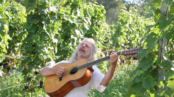 Walter Dieterle mit rauchiger Stimme und zwölfseitiger Gitarre inmitten der Weinbergreben. GEA-FOTO: ANDREAS FINK