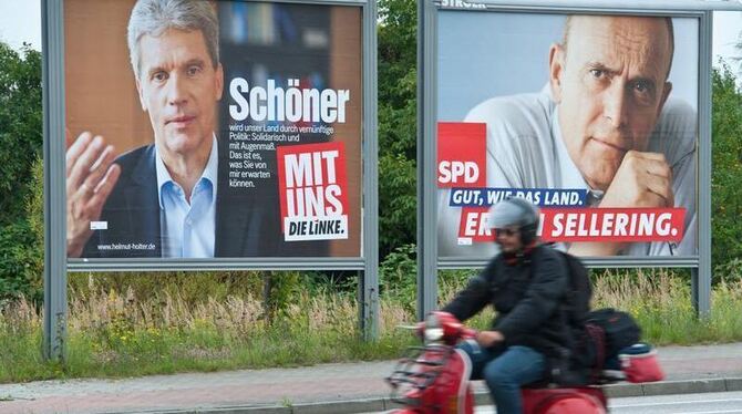 Die Porträts der Spitzenkandidaten der Partei Die Linke, Helmut Holter (l), und der SPD, Erwin Sellering werben auf großen Wa