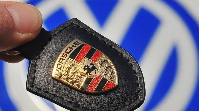 Das Porsche-Firmenlogo vor dem Logo des Volkswagen-Konzerns.