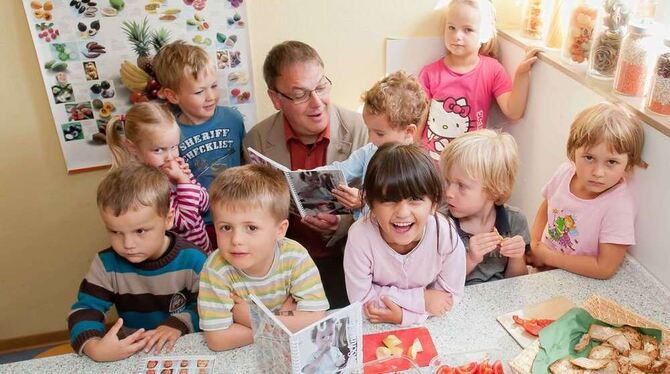 Spannende Lektüre: Betzingens Bezirksbürgermeister Thomas Keck und die kleinen Autoren des »Lecker Schmecker«-Kochbuchs mit den