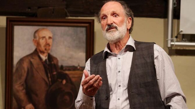 Gerhard F. Schmid bei seinem Vortrag im Dorfgemeinschaftshaus vor dem Porträt von Hans Reyhing. FOTO: KOZJEK