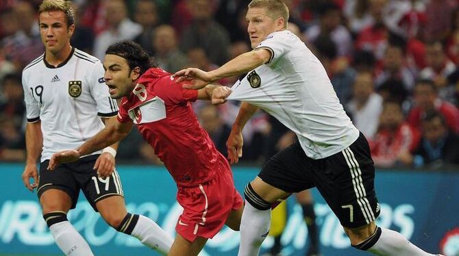 Selcuk Inan (M) ist äußerst agil und kämpft gegen Bastian Schweinsteiger (r) mit allen Tricks. Photo: Hannibal