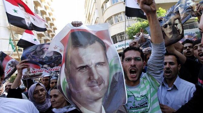 Anhänger des Regimes in Damaskus mit einem Bild von Präsident Assad. Foto: Nabil Mounzer