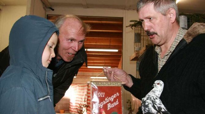 Norbert Gulde-Zeiler, rechts, holt sich mit seiner Taube der Rasse Modeneser Schecke den Meistertitel und das Band, der vierjähr