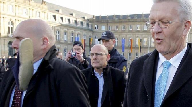 Ein Personenschützer des baden-württembergischen Ministerpräsidenten Winfried Kretschmann (r) wird von einem Schuh getroffen. Fo