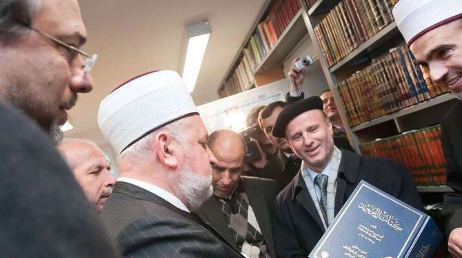 In der Bibliothek: Großmufti Mustafa Ceri hält eines der 3 000 Bücher in der Hand, die Instituts-Leiter Omar Hamdan (rechts nebe