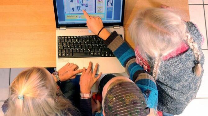 Schulkinder sitzen an einem Laptop. Foto: Bernd Weißbrod (Archivbild)