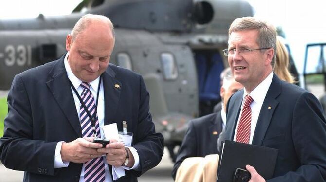 Christian Wulff (r) und sein damaliger Sprecher Olaf Glaeseker im Herbst 2010 auf einem Flugplatz in Lausanne. Foto: Rainer J