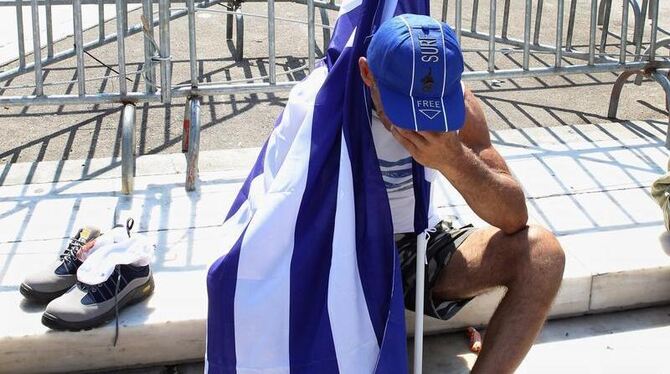 Ein Demonstrant mit einer griechischen Flagge am Rande einer Demonstration in Athen. Foto: Pantelis Saitas/Archiv