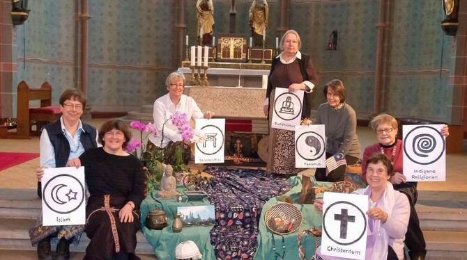 Das ökumenische Vorbereitungsteam in der Reutlinger St. Wolfgangskirche mit Schildern der vielen Religionen Malaysias. Um die bu