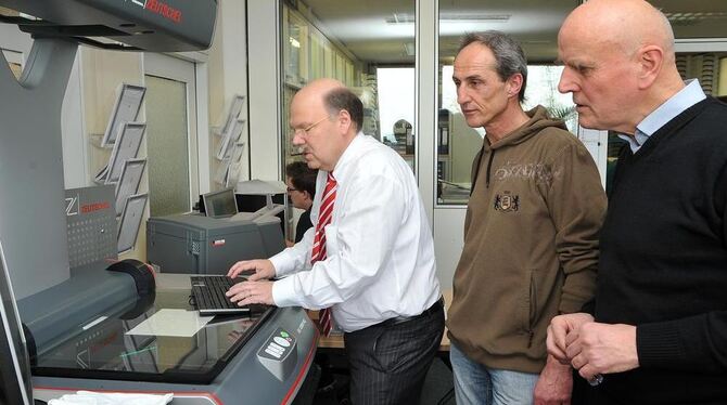 Einsatz im Scan-Service der Gustav-Werner-Stiftung: GEA-Verleger Valdo Lehari jr. (links) am Gerät mit dem Vorstandvorsitzenden Lothar Bauer (rechts) und Abteilungsleiter Jürgen Knoll.