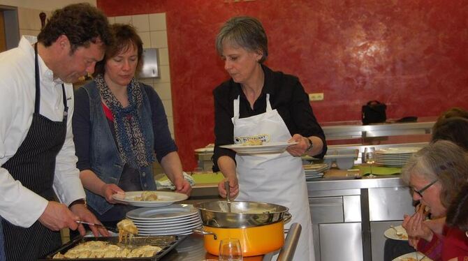 Während Jürgen Autenrieth Elisabeth Engst geschmorten Chicorrée mit Chili-Brie auf den Teller legt und Karin Kuhn-Schmidgall ihn