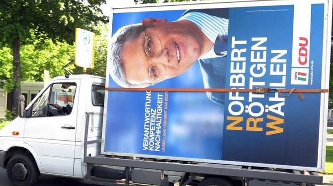 Ein Wahlplakat mit CDU-Spitzenkandidat Norbert Röttgen wird in Düsseldorf weggefahren. Foto: Martin Gerten