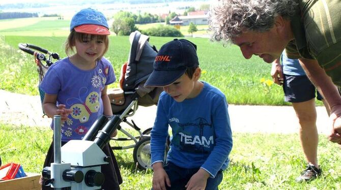 Schmetterling auf dem T-Shirt und unterm Mikroskop: Irina und Johannes sind neugierig, was Thomas Klingseis ihnen zu zeigen hat.