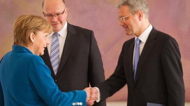 Bundeskanzlerin Merkel schüttelt dem scheidenden Umweltminister Röttgen (r) die Hand. Dahinter dessen Nachfolger Peter Altmai