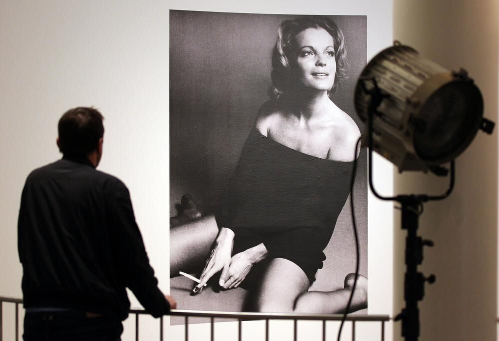 Ein Mann schaut sich ein Filmplakat mit der Schauspielerin Romy Schneider an. Foto: Oliver Berg