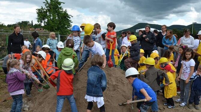 Kinder und Gemeinderäte in Aktion: Wenn so viele schaffen, dann klappt es mit dem Kinderhaus.  GEA-FOTO: BARAL