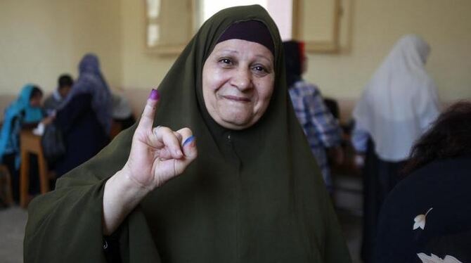 Gewählt! Eine Ägypterin hält ihren in Tinte getauchten Finger nach ihrer Stimmabgabe hoch. Foto: Andre Pain