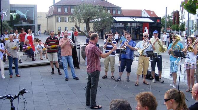 Gottesdienst-Spaziergang: Auftakt auf dem Lindenplatz mit dem Posaunenchor und singenden Schnäppchenjägern.  FOTO: BÖRNER