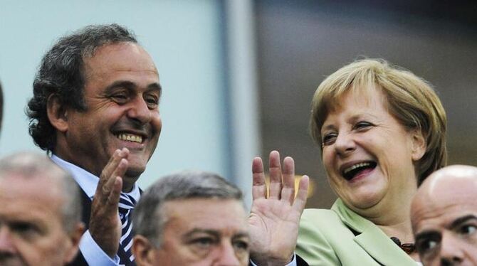 Bundeskanzlerin Angela Merkel (r) und UEFA-Präsident Michel Platini haben auf der Tribüne viel zu Lachen. Foto: Gerry Penny