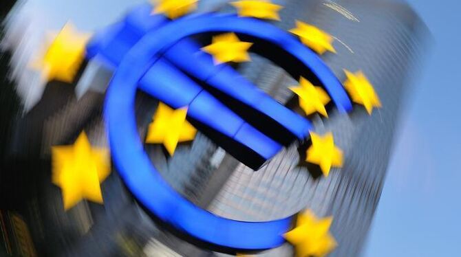 Die Euro-Skulptur leuchtet in Frankfurt am Main vor der Zentrale der Europäischen Zentralbank. Foto: Uwe Anspach/Archiv