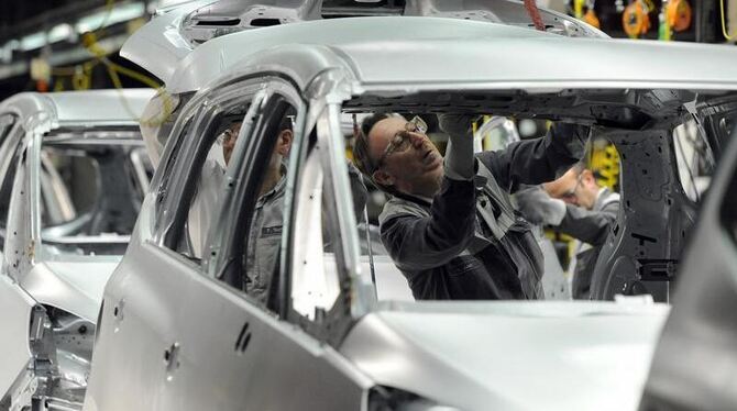 Mitarbeiter überprüfen im Opel-Werk in Bochum die Schweißnähte des Zafira-Tourer. Foto: Caroline Seidel / Archiv