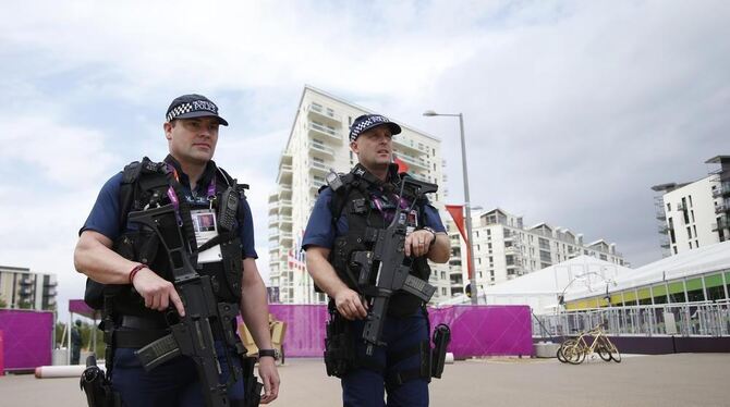 Schwerbewaffnete Polizisten sichern das Olympische Dorf.