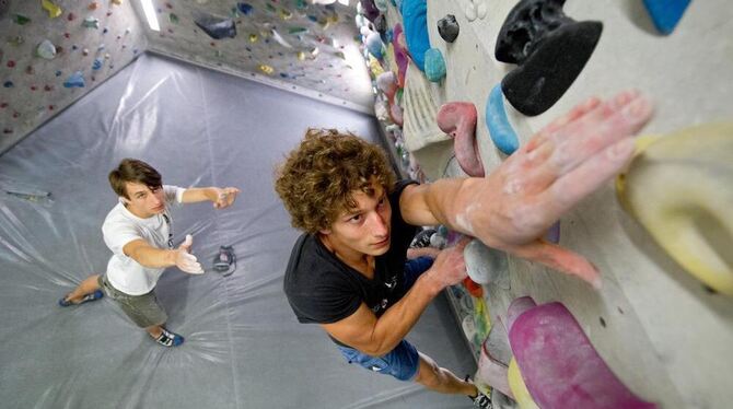 Philipp Eric Hans (rechts) und sein Trainer Alexander Hille lachen im Boulderbereich einer Kletterhalle in Stuttgart.