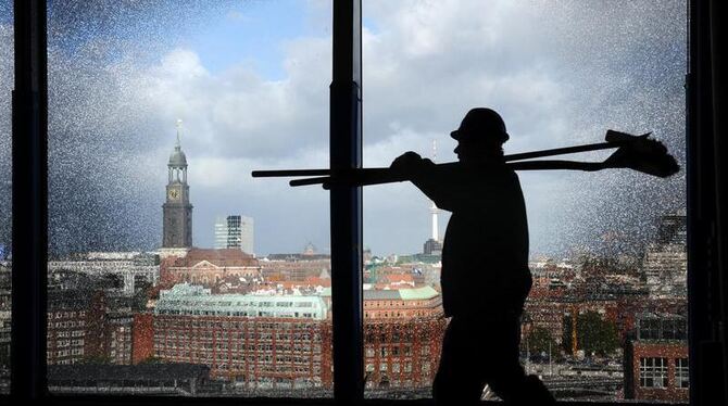 Ein Bauarbeiter geht in Hamburg auf der Baustelle der Elbphilharmonie an einem der Spezial-Fenster vorbei. Foto: Marcus Brand