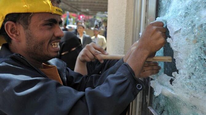 Ein Demonstrant versucht, ein Fenster der US-Botschaft in Sanaa zu entfernen. Foto: Yahya Arhab