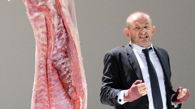 Shylock (Dominique Horwitz) boxt auf eine Schweinehälfte ein. Foto: Daniel Bockwoldt