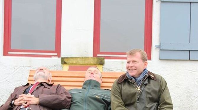 Test trotz Nieselregens (von links): Landrat Thomas Reumann und Dr. Dietmar Götze vom Bundesforst auf einer der Holzliegen am Sternenberg. Münsingens Bürgermeister Mike Münzing blieb lieber sitzen. GEA-FOTO: DEWALD