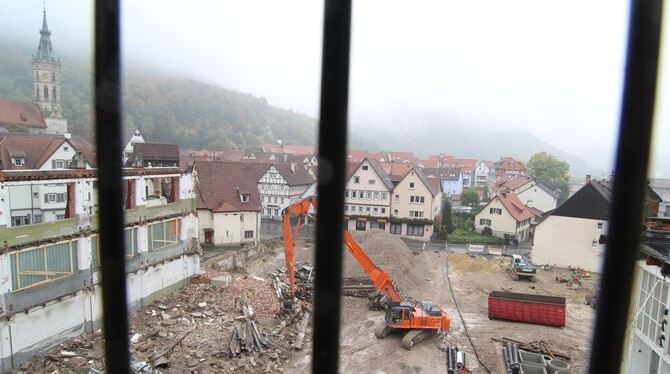 Betreten der Baustelle verboten: Der Blick vom Uracher Parkhaus zeigt die Dimension der Elsach-Center-Baustelle. Links im Bild ist die Mauer zu sehen, die vom Manz-Bau erhalten bleibt. Wo gerade der Bagger die letzten Eisenteile abträgt, entstehen Fachmärkte. Im östlichen Teil des Areals entsteht das Pflegeheim der Bruderhaus-Diakonie - auf dem Dach des Rewe-Supermarkts. GEA-FOTO: FINK