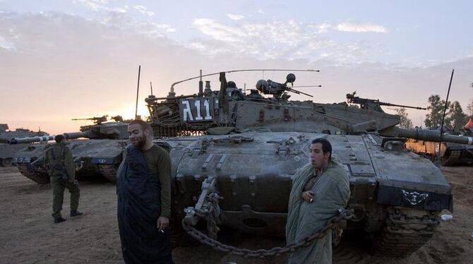 Israelische Soldaten rauchen am ersten Morgen der Waffenruhe Zigaretten. Foto: Jim Hollander