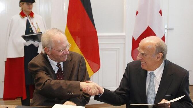 Finanzminister Wolfgang Schäuble (l) und sein Schweizer Amtskollege Hans-Rudolf Merz unterzeichnen das Steuerabkommen. Foto: