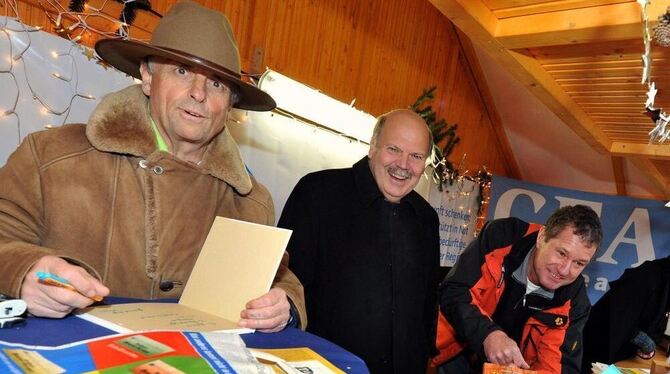 Auch dieses Jahr wollen Gerhard Raff (links neben GEA-Verleger Valdo Lehari jr.) und Gunter Haug wieder Bücher zugunsten von »GEA-Leser helfen« auf dem Reutlinger Weihnachtsmarkt verkaufen.  ARCHIVFOTO: PACHER