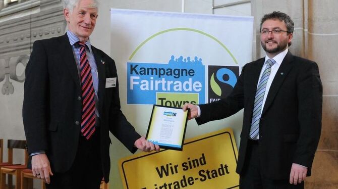 Urkundenübergabe durch Fairtrade- Ehrenbotschafter Manfred Holz an Mössingens Oberbürgermeister Michael Bulander. GEA-FOTO: MEYE