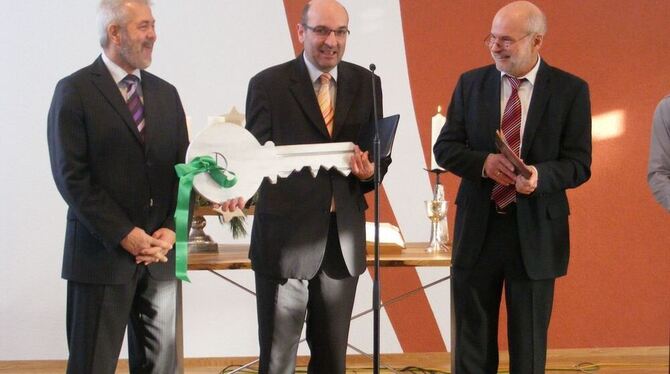 Pastor Ulrich Ziegler mit dem symbolischen neuen Schlüssel für den Anbau der Friedenskirche, den ihm Architekt Harald K. Eppler