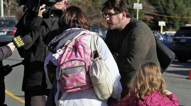 Vieles bleibt noch unklar: Medienvertreter interviewen eine Mutter und ihr Kind vor der Schule. Foto: Jeff Spooner