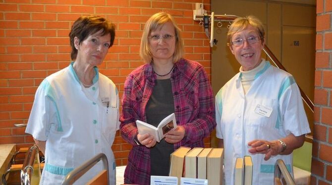 Die Grünen Damen Anne Westerkamp (links) und Ilse Kling rahmen Patricia Kolb, die Verwaltungschefin der Ermstalklinik, ein. FOTO