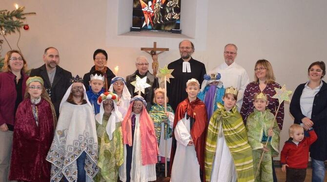 Sternsinger im farbenprächtigen Gewand, dahinter Angelica Tittel (links neben dem Kreuz). FOTO: MARA SANDER